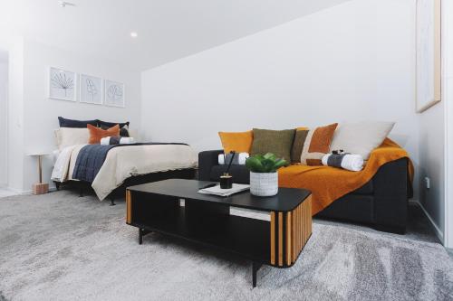 a living room with a couch and a bed at 1 bed Central City Deluxe w/carpark in Christchurch
