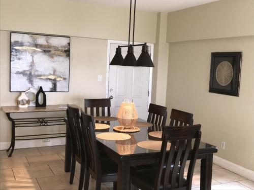 a dining room with a black table and chairs at Island House Beach Resort 9N in Siesta Key
