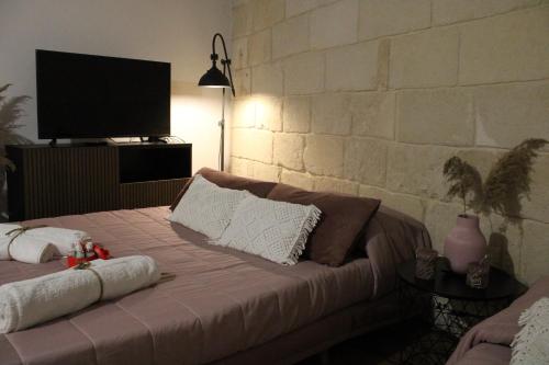 a bedroom with a bed with a tv on a wall at BETÌ in Taranto