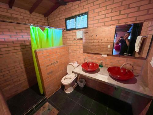 baño con 2 lavabos rojos y aseo en Finca Villa Melita, Privada en Piedecuesta, en Piedecuesta