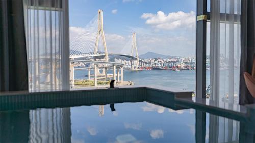 a swimming pool with a view of a bridge at Yeongdo Grandbern Hotel in Busan