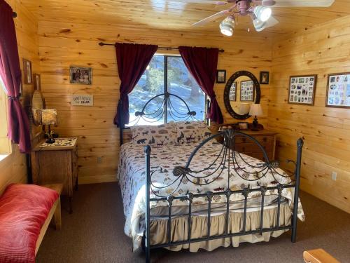 ein Schlafzimmer mit einem Bett in einem Blockhaus in der Unterkunft Cox Cabin On The River in Red River