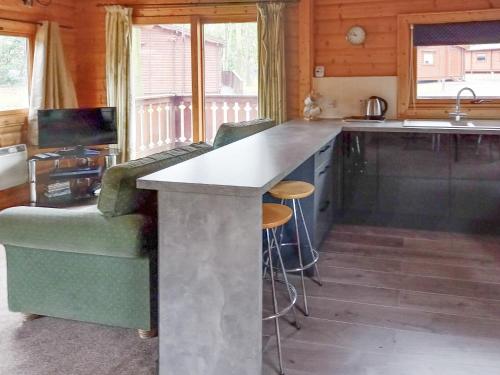 a kitchen with a counter and a couch and a sink at Paradise Lodge-uk31996 in Legbourne