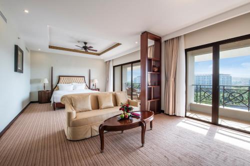 a hotel room with a bed and a couch and a table at Vinpearl Resort & Spa Phu Quoc in Phú Quốc