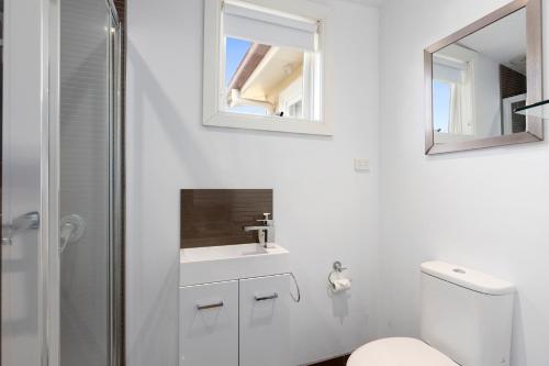 a bathroom with a toilet and a sink and a mirror at Healesville Garden Grandview in Healesville