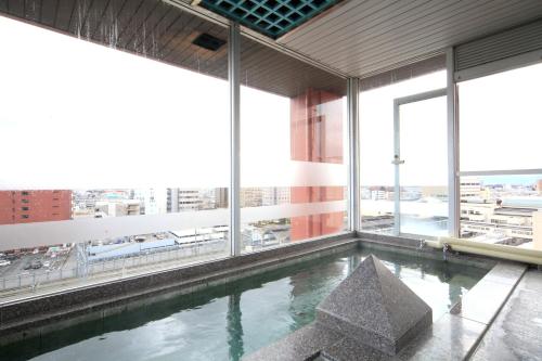 a swimming pool in the middle of a building with windows at Nagano Daiichi Hotel in Nagano