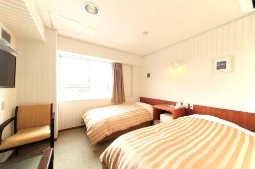 a hotel room with two beds and a window at Nagano Daiichi Hotel in Nagano