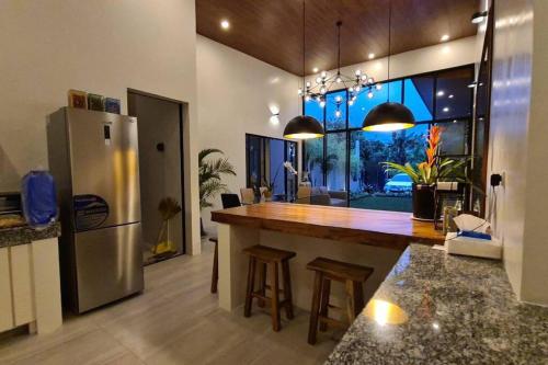- une cuisine avec un grand comptoir et un réfrigérateur dans l'établissement The Great Molave DELUXE ROOM, à Cavite