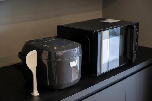 a microwave sitting on top of a counter with a spatula at nabe cape in Tagawa