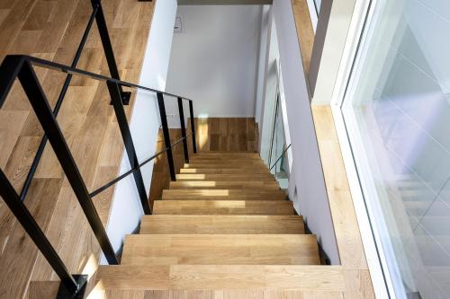a staircase in a house with wooden floors and a glass wall at nabe cape in Tagawa