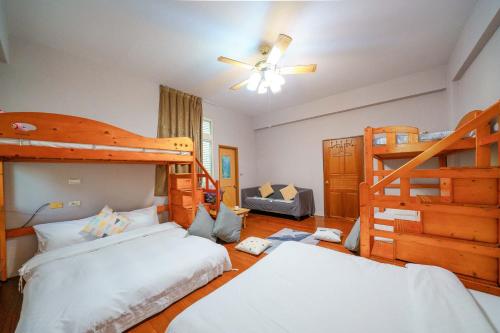 twee bedden in een kamer met twee stapelbedden bij Wind Blown Homestay in Hualien