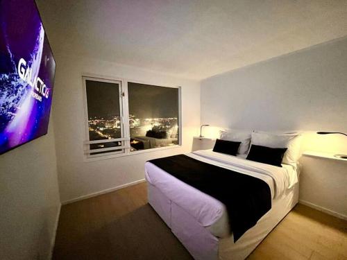 a bedroom with a large bed and two windows at Departamento para empresas y grupos in Calama
