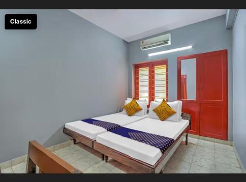 a bedroom with a bed and a red door at KKP Tourist Home in Trivandrum
