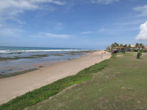 a beach with a person walking on the sand at Pousada Ipitanga IV in Lauro de Freitas