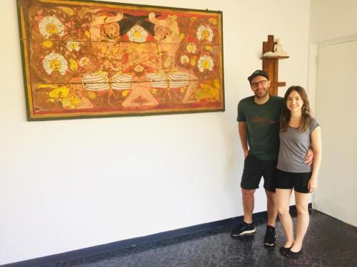 a man and a woman standing in front of a painting at The Lake Round Guest House in Kandy