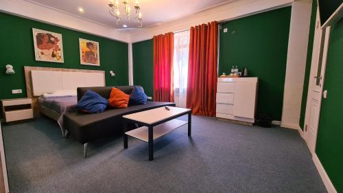 a green bedroom with a couch and a table at CryptoHotel.Club in Almaty