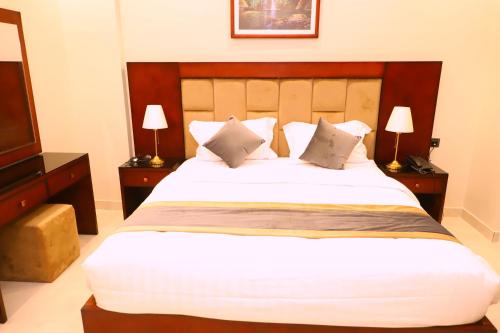 1 dormitorio con 1 cama grande y TV en فندق الأفنيوز بالرس en Al Rass