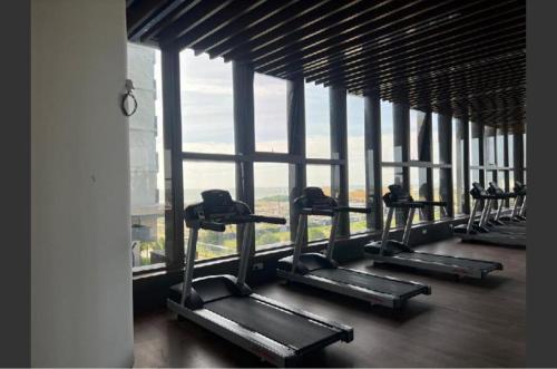 a row of treadmills in a building with a large window at bali residensi in Melaka