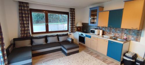a living room with a couch and a kitchen at Pinball apartment in Feldkirchen in Kärnten