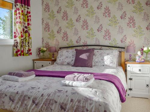a bedroom with a bed with two towels on it at Bryn Rodyn in Llanfair-Dyffryn-Clwyd