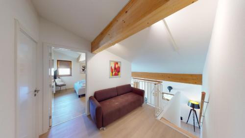 a living room with a brown couch in a room at Walensee House & Apartments in Unterterzen