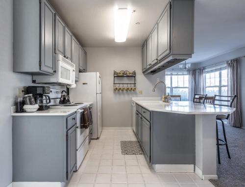 eine Küche mit grauen Schränken und einem weißen Kühlschrank in der Unterkunft Alleys 22 with Direct Deck Access in Hood River