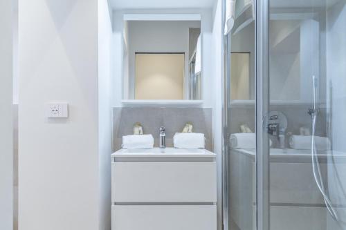 Un baño blanco con dos lavabos y una ducha. en VickyLù - City Center - by Host4U, en Pavia