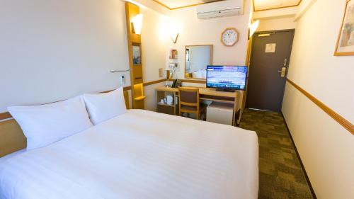 a bedroom with a bed and a desk with a computer at Toyoko Inn Shin-Osaka Chuo-guchi Shinkan in Osaka