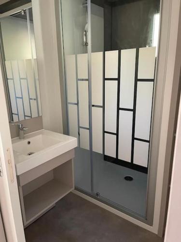une salle de bain avec une douche en verre et un lavabo dans l'établissement Chalet à louer - 52m2 - Landes, à Saint-Geours-de-Maremne