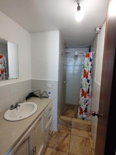 uma casa de banho com um lavatório e um chuveiro em Mi Casa em Quito