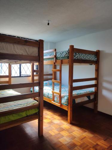 a room with three bunk beds in a room at Mi Casa in Quito