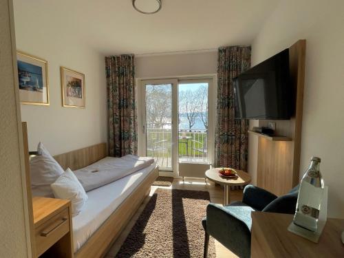 a hotel room with a bed and a television at Iris am See garni in Radolfzell am Bodensee