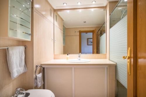 een badkamer met een wastafel en een spiegel bij Espectacular primera linea de playa in Torremolinos