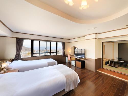 山ノ内町にあるホテル椿野のベッド2台、薄型テレビが備わるホテルルームです。