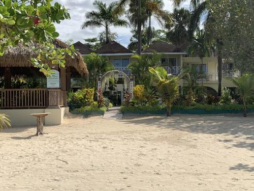 a resort on the beach with a building at Family Comfort in Jamaica - Enjoy 7 miles of White Sand Beach! villa in Negril