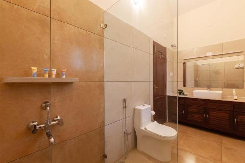 uma casa de banho com um WC, um lavatório e um espelho. em StayVista at Crystal Homestay with Breakfast & Bicycle em Madikeri