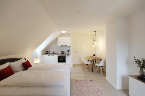 a white bedroom with a bed and a kitchen at Hotel Obermaier in Munich