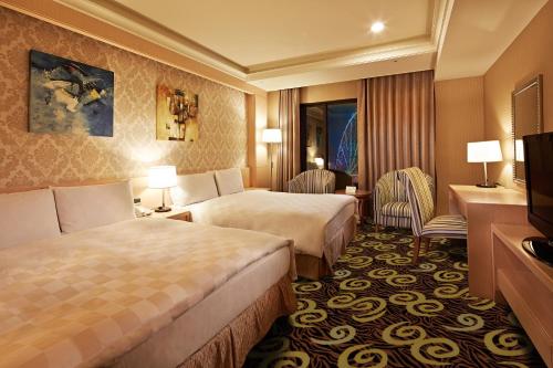 大樹區的住宿－義大天悅飯店，酒店客房设有两张床和电视。