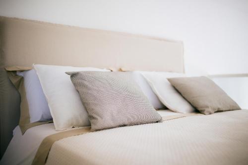 a bed with white pillows on top of it at Borgo Chiancarosa in Putignano
