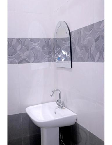 Hotel UV, Haryana في Nārnaul: حمام مع حوض ومرآة