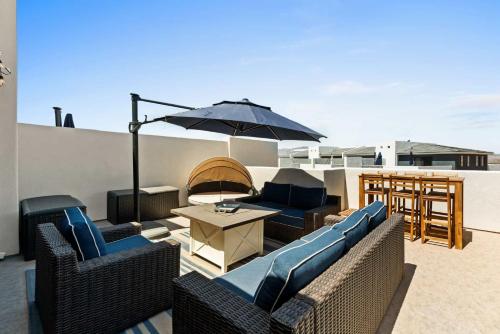 un patio con mobili e ombrellone sul tetto di Anchor Oasis #87 condo a St. George