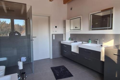 a bathroom with two sinks and a shower at Moderne Ferienunterkunft/Wohnung in Burgthann