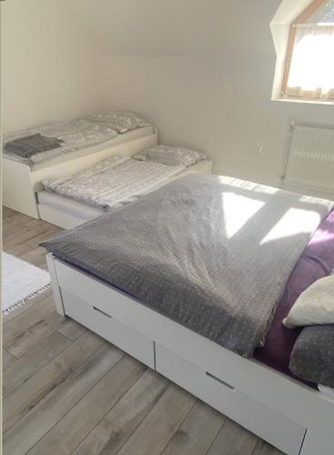 two twin beds in a room with wooden floors at Hotel SEVERKA in Zákopčie