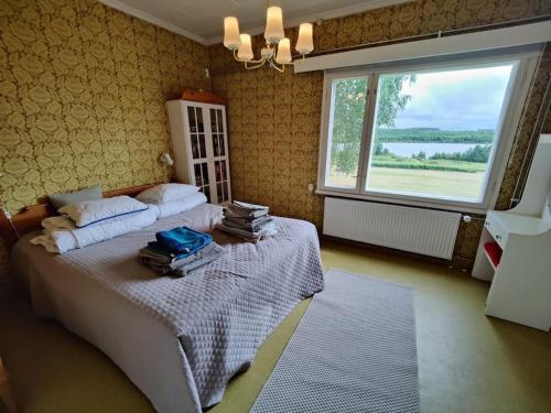 - une chambre avec un lit et une grande fenêtre dans l'établissement Lappish Summerhouse by the River, à Kiemunkivaara