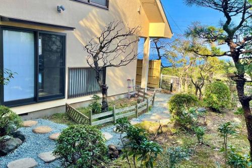 Ajiro的住宿－雅 南熱海 温泉別荘 Ocean View Hotspring Villa，前面有花园的房子