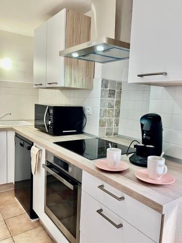 une cuisine avec deux assiettes roses sur un comptoir dans l'établissement La Vista, à Bastia