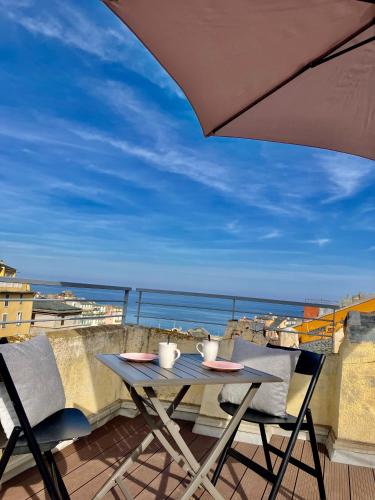 een tafel en stoelen op een balkon met een parasol bij La Vista in Bastia