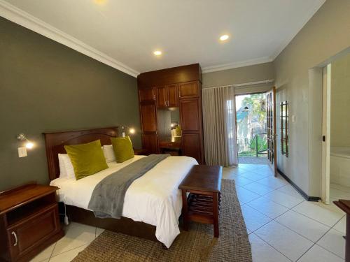 a bedroom with a large bed with green pillows at Farquhar Lodge in Ladysmith