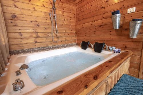 a large bath tub in a wooden bathroom at שופרא ריזורט - וילה ובקתות - נופש וספורט Shoofra Resort Vacation Nature and Sport in Manot