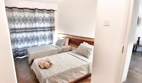 ein kleines Zimmer mit 2 Betten und einem Fenster in der Unterkunft Savanna Tree Apartments - self catering town center in Livingstone